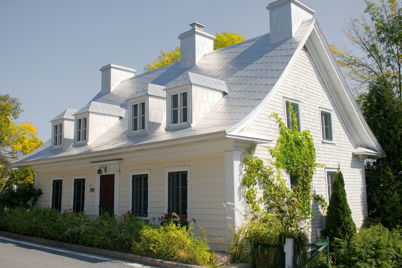 A white house with black shutters and a red door